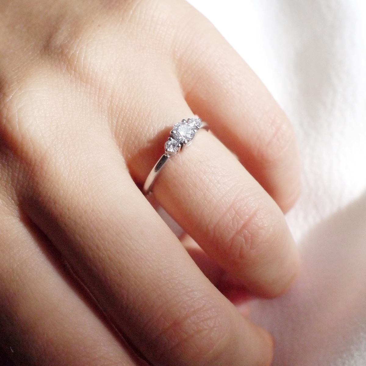 Mão feminina usando Anel de noivado minimalista feito a mão em ouro 18k com diamante de 38p