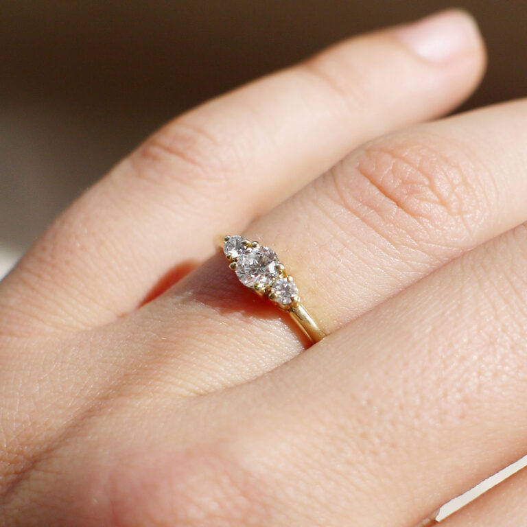 Mão feminina usando Anel de noivado minimalista feito a mão em ouro 18k com diamante de 38p