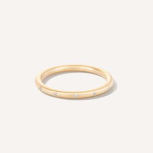 Aliança de aro redondo 1,8mm minimalista com diamantes feita a mão em ouro 18k para casamentos sobre fundo branco
