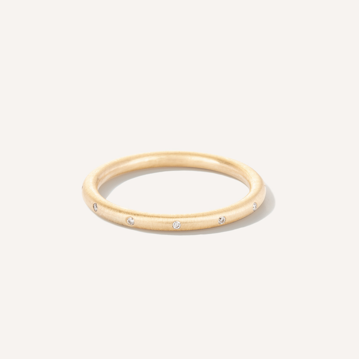 Aliança de aro redondo 1,8mm minimalista com diamantes feita a mão em ouro 18k para casamentos sobre fundo branco