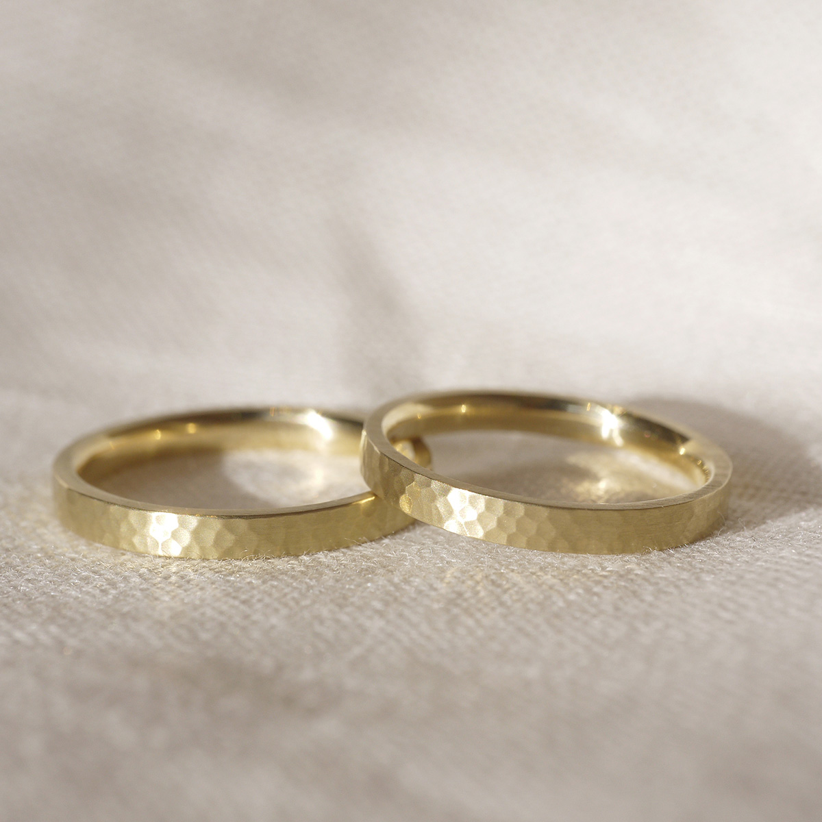 Par de Alianças de 2,5mm minimalistas de textura martelada feitas a mão em ouro 18k sobre tecido branco