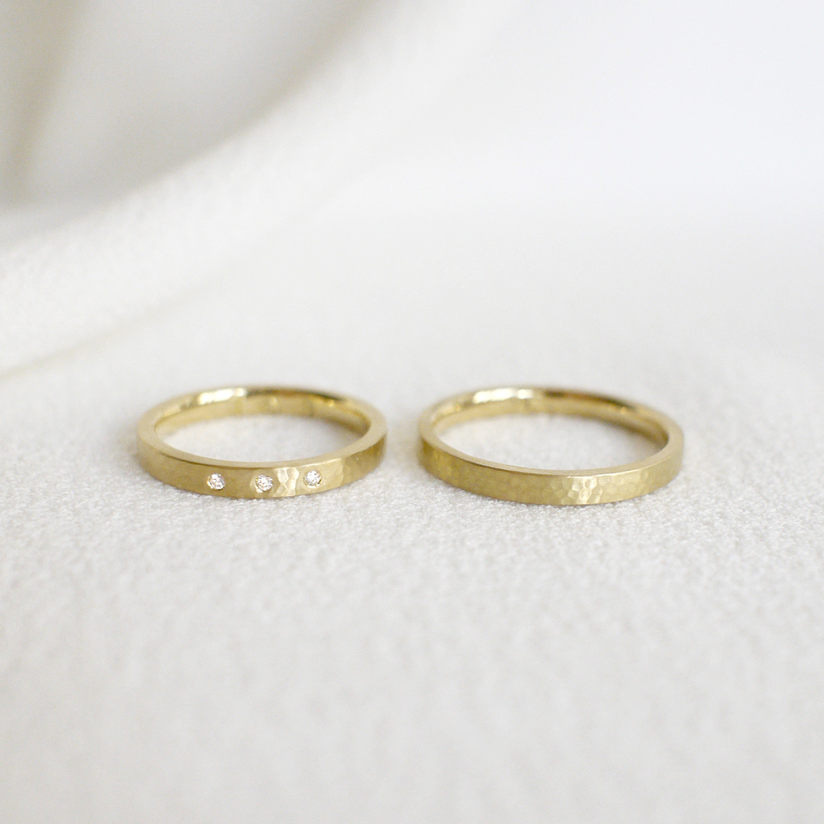 Par de Alianças de 2,5mm minimalistas de textura martelada feitas a mão em ouro 18k sobre tecido branco