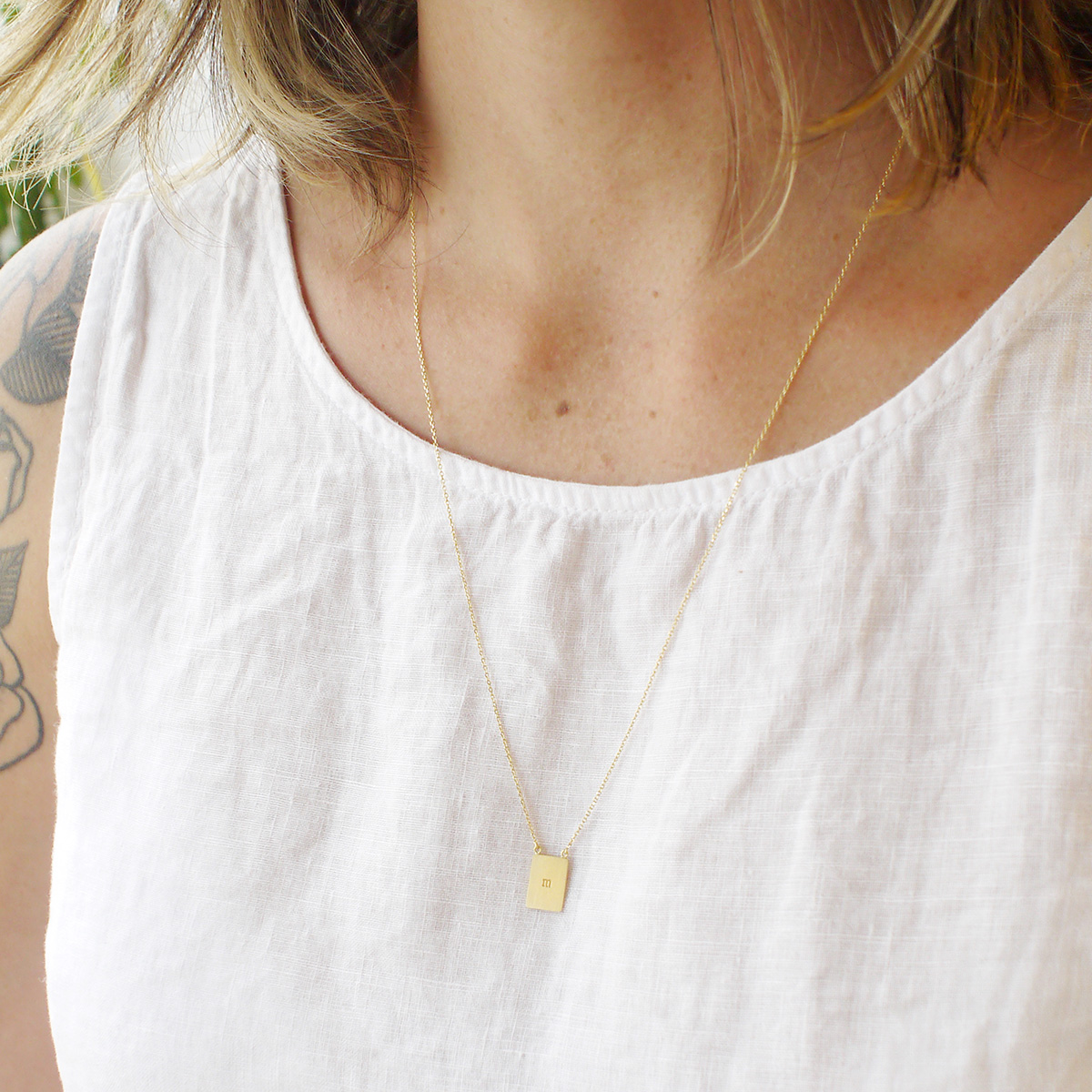 Mulher usando Colar escapulário com duas placas de gravação personalizável feitas a mão em ouro 18k