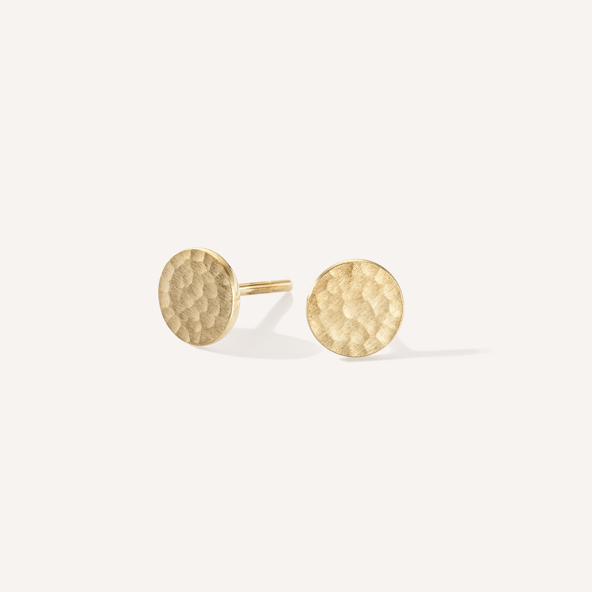 Brinco minimalista de formato circular feito a mão com um disco de ouro 18k martelado