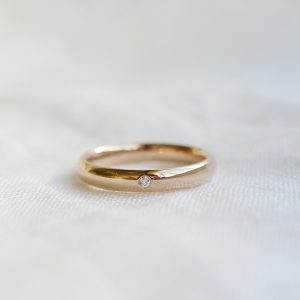Aliança minimalista boleada feita a mão em ouro 18k com diamante para casamentos