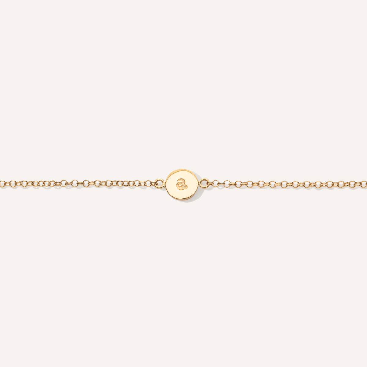 pulseira com plaquinha redonda feita à mão em ouro 18k com letra gravada