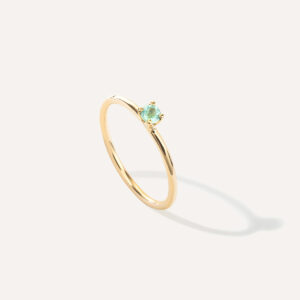 anel solitário em ouro 18k amarelo com pedra turmalina paraíba natural sobre superfície branca