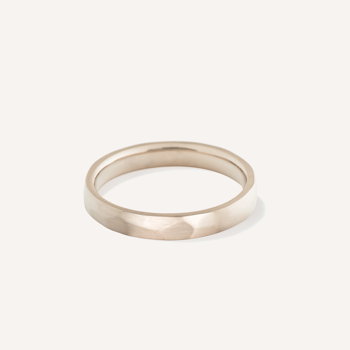 Aliança de casamento feita a mão em ouro 18k facetada minimalista sobre fundo branco