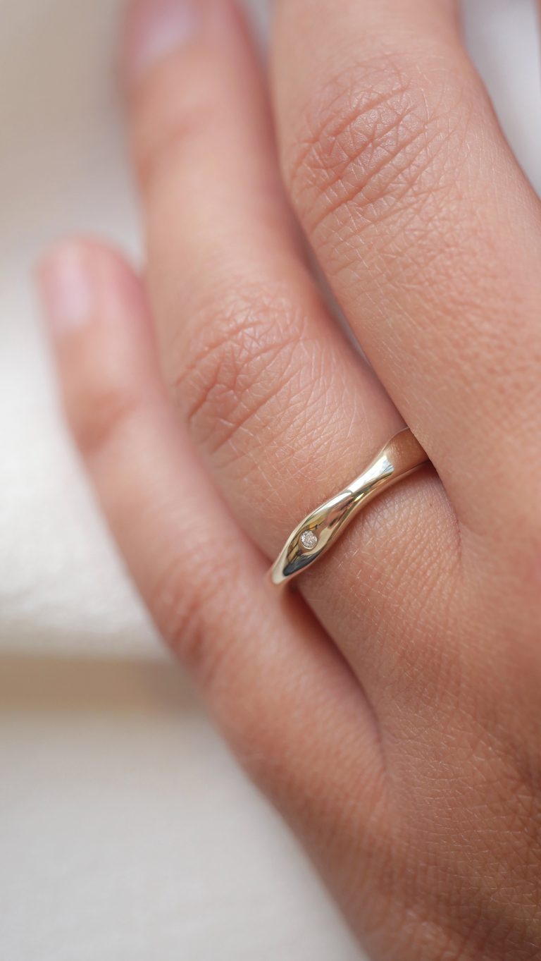 Mão usando Aliança irregular orgânica minimalista feita a mão em ouro 18k para casamentos