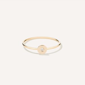 Anel de aro fino minimalista feito a mão em ouro 18k com diamante no centro sobre tecido branco