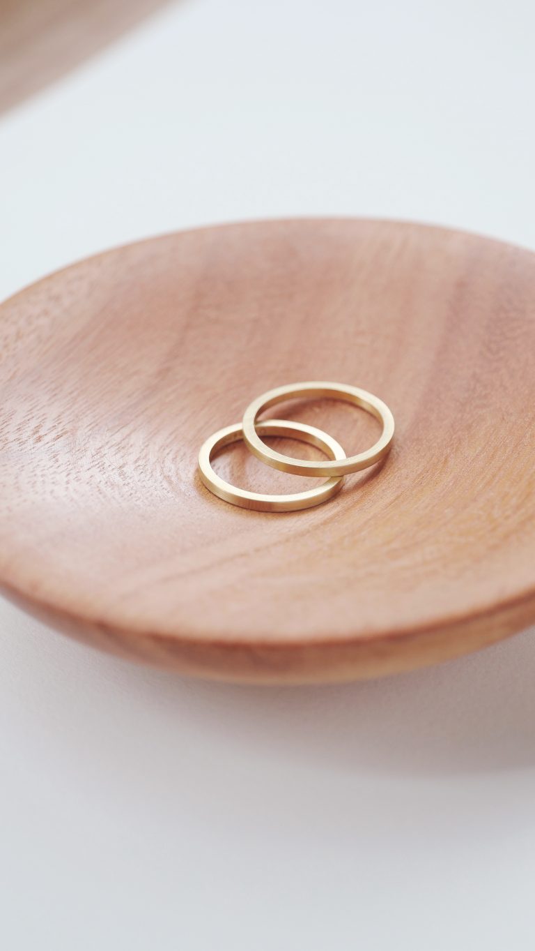 pote de madeira com um par de alianças em ouro amarelo 18k