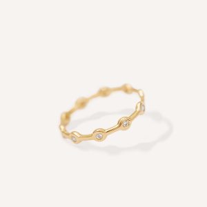 Aliança minimalista em ouro 18k feita a mão com diamantes sobre fundo branco para casamentos