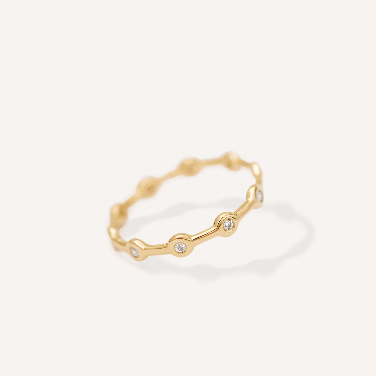 Aliança minimalista em ouro 18k feita a mão com diamantes sobre fundo branco para casamentos