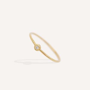 Anel de aro fino minimalista feito a mão em ouro 18k com diamante sobre fundo branco