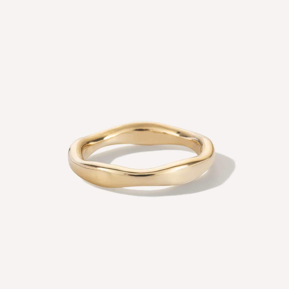 Aliança irregular orgânica minimalista feita a mão em ouro 18k para casamentos sobre fundo branco