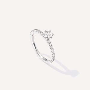 Anel solitário cravejado minimalista de diamantes em ouro 18k sobre fundo branco