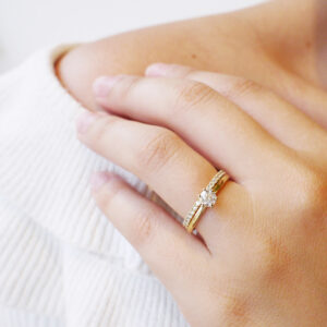 Mulher usando anel solitário minimalista com diamantes de 30p em ouro 18k