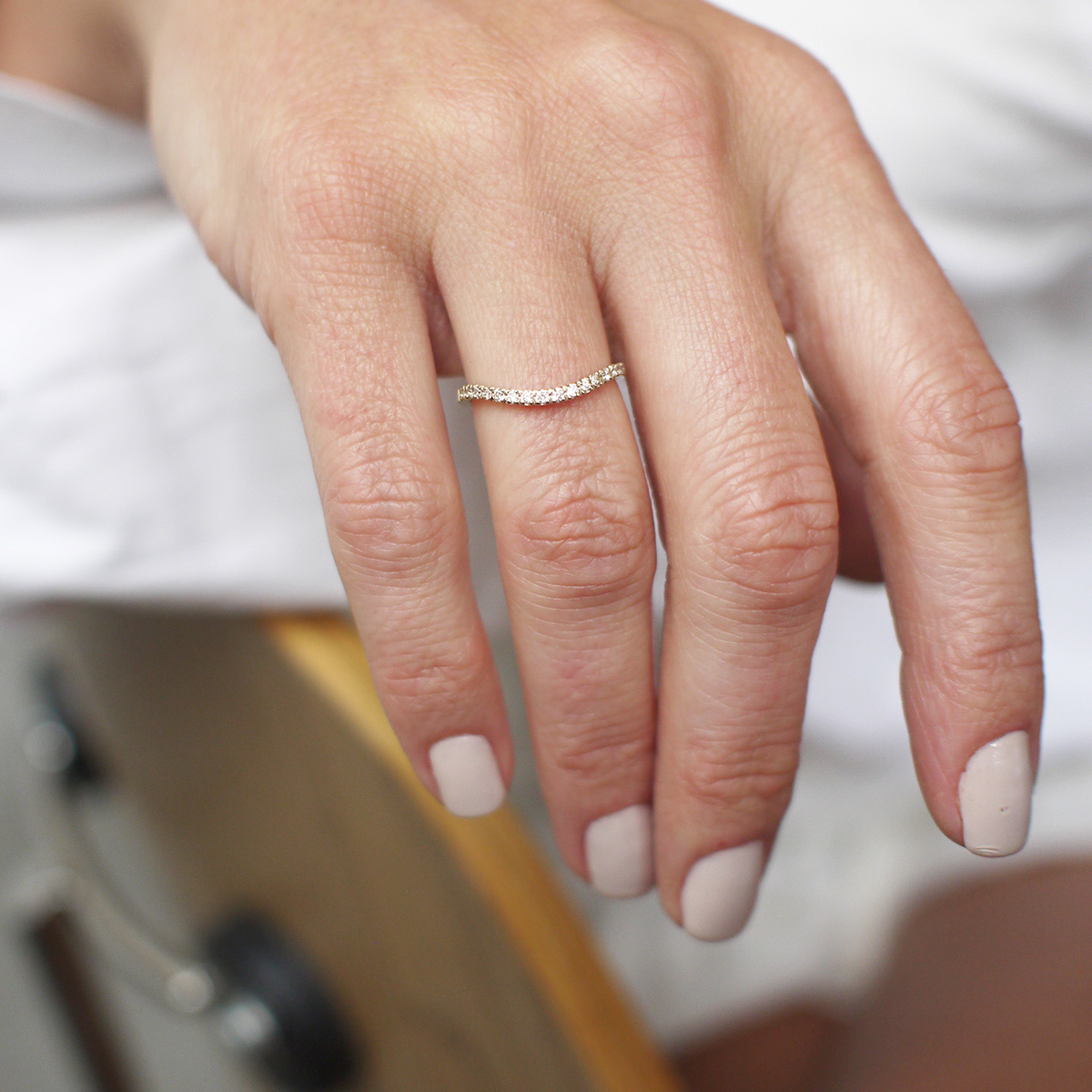 Mulher usando aliança cravejada minimalista feita a mão em ouro 18k para casamentos