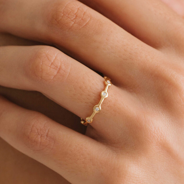 Mão com aliança minimalista em ouro 18k feita a mão com diamantes para casamentos
