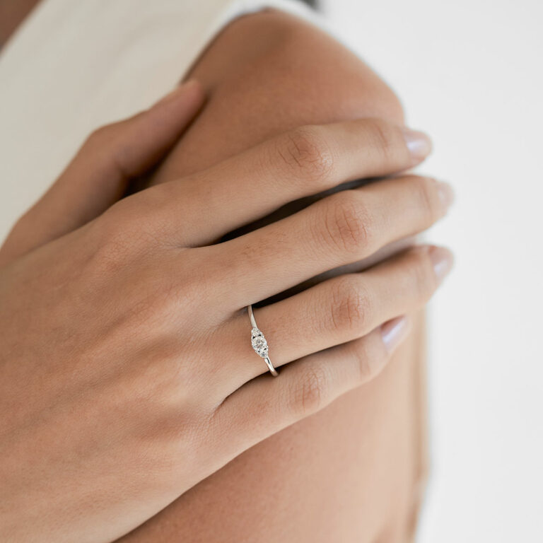 Mão feminina usando Anel de noivado em ouro 18k com diamante de 28p minimalista feito a mão