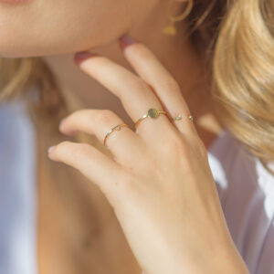 Mão feminina usando anel martelado em ouro 18k com diamante minimalista para noivado