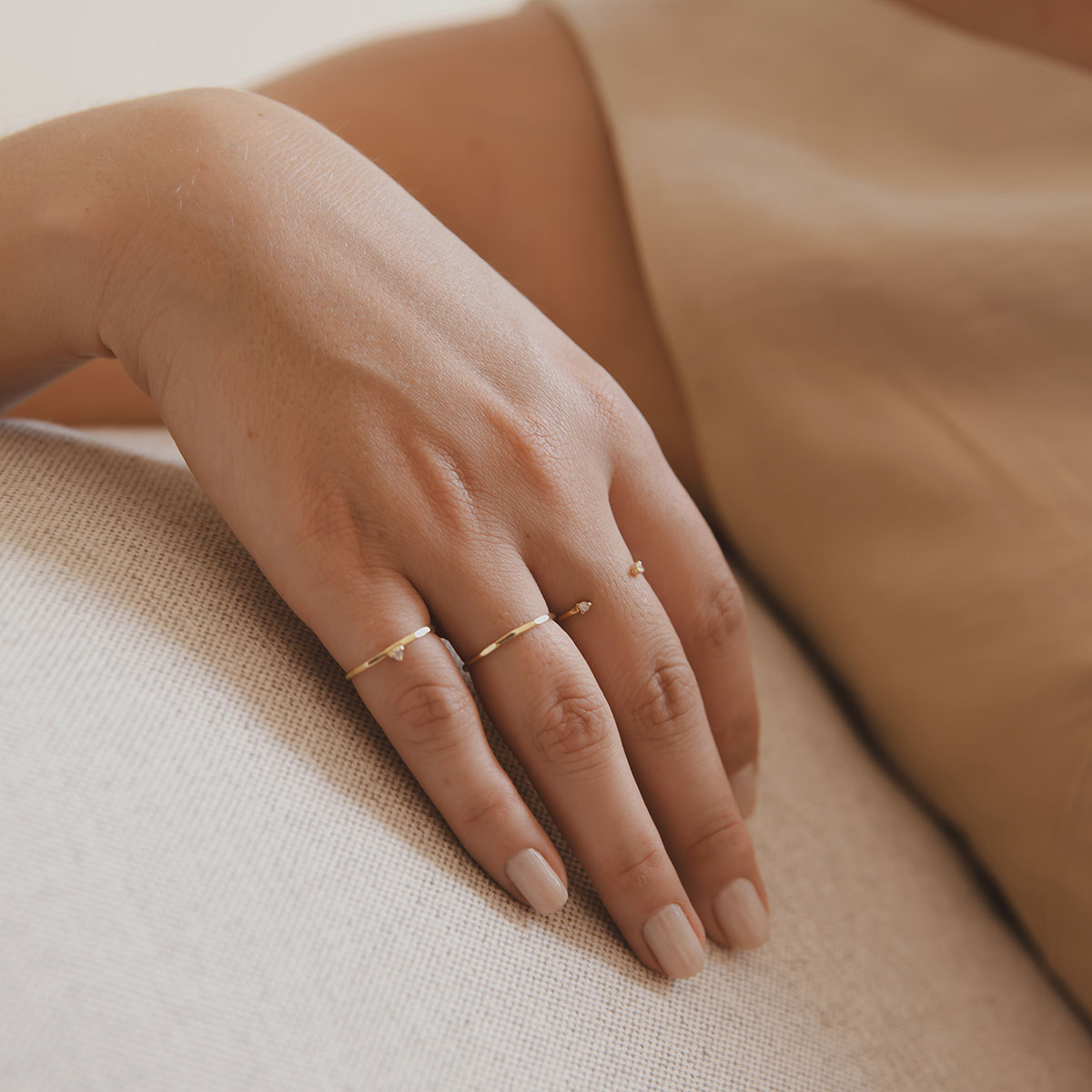 Mão feminina usando anel martelado em ouro 18k com diamante minimalista