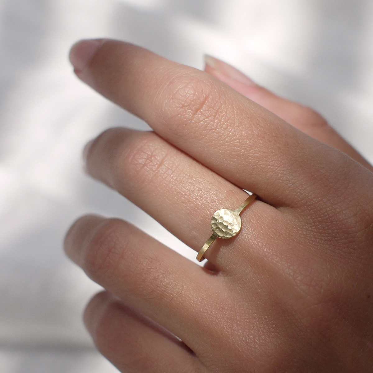 Mão feminina usando Anel minimalista feito a mão em ouro 18k com círculo martelado na frente