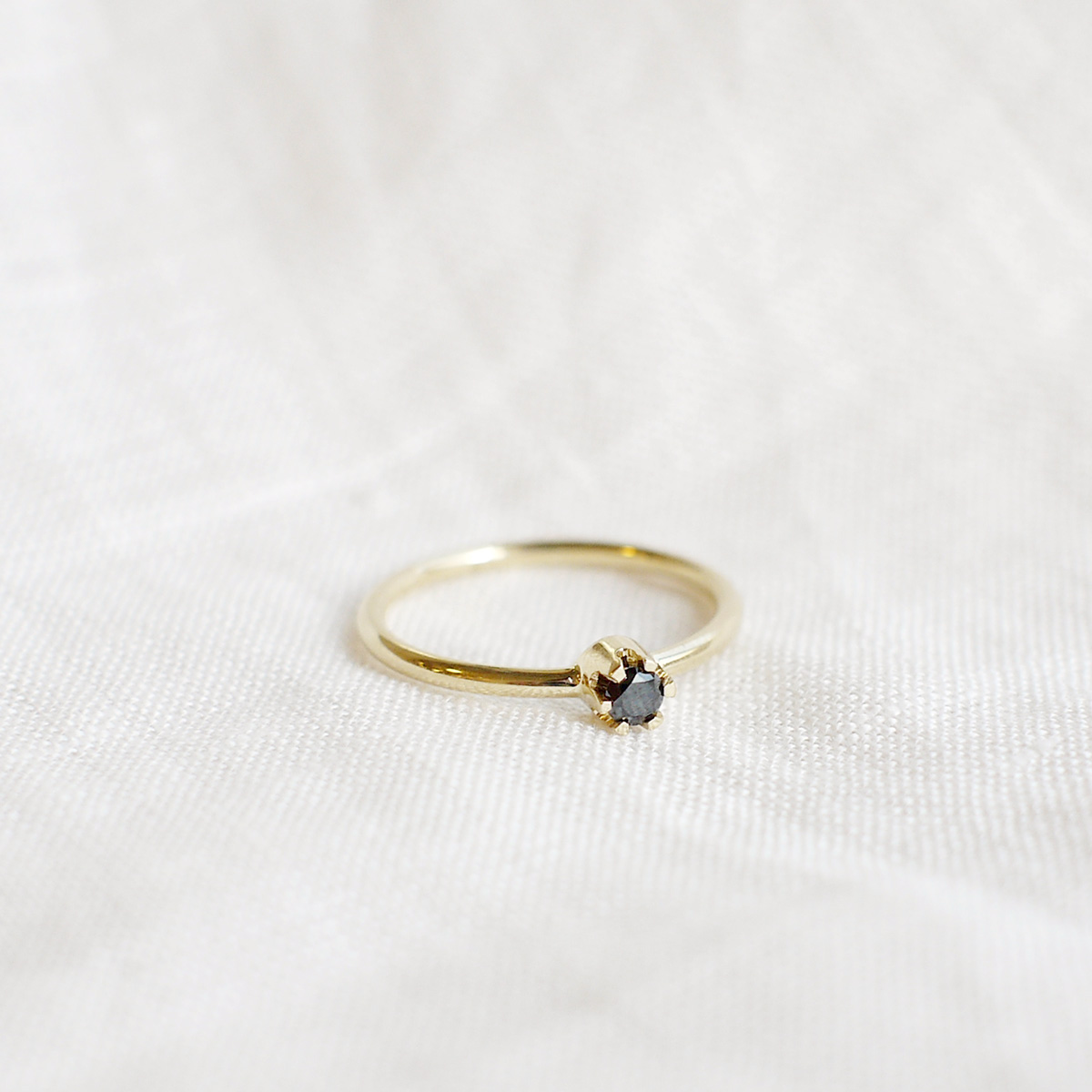 anel solitário de noivado em ouro 18k e diamante negro minimalista e feito à mão sobre tecido