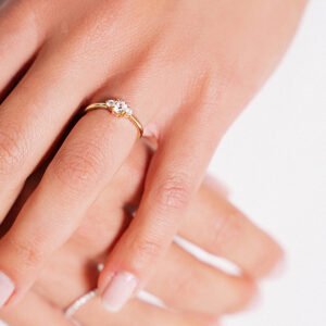 Mulher usando Anel de noivado minimalista e feito a mão em ouro 18k com três diamantes