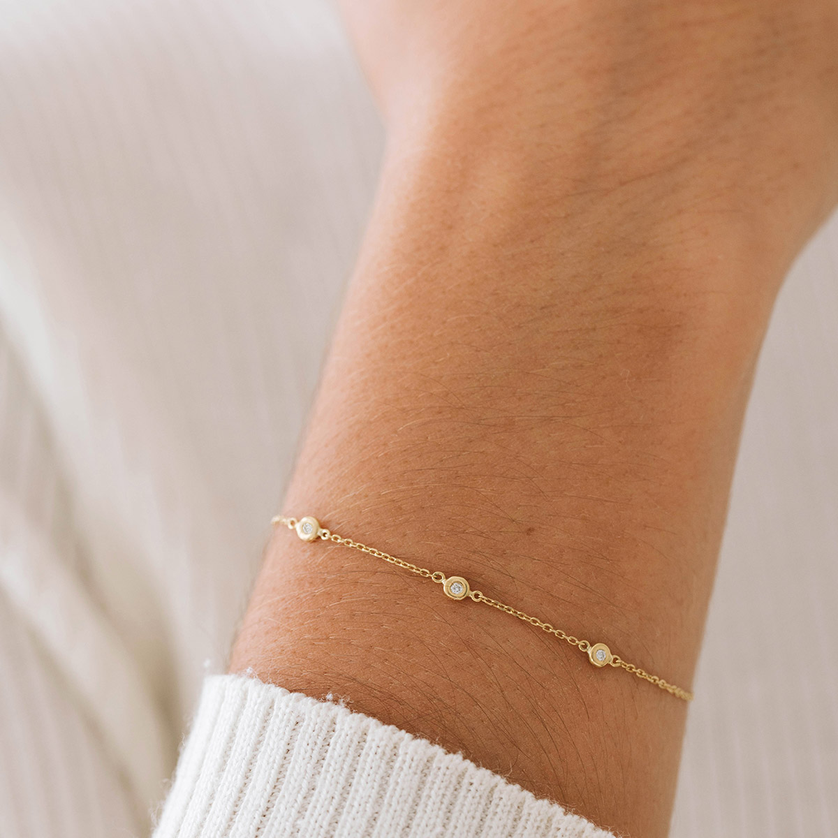 Mulher usando Pulseira em ouro 18k feita a mão com três diamantes