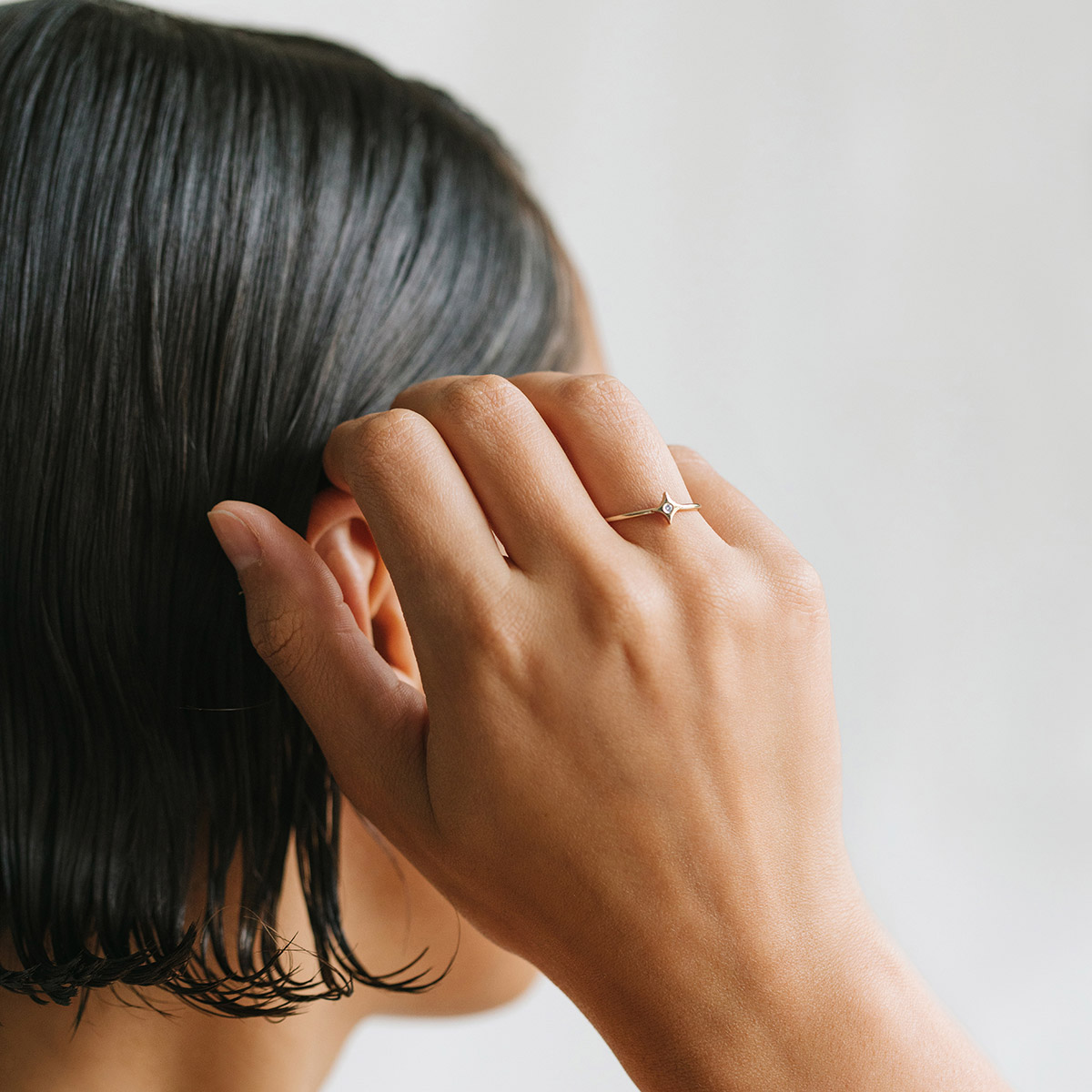 Mulher usando Anel minimalista feito a mão em ouro 18k com estrela e diamante no centro