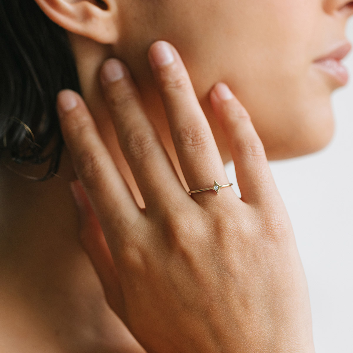 Mulher usando Anel minimalista feito a mão em ouro 18k com estrela e diamante no centro