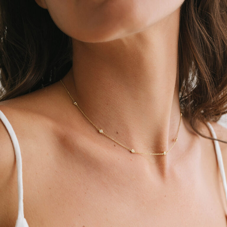 Mulher usando Choker minimalista feita a mão em ouro 18k com sete diamantes em sua volta