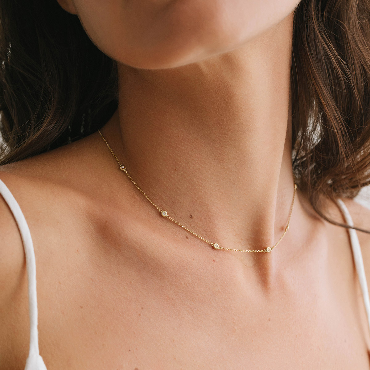 Mulher usando Choker minimalista feita a mão em ouro 18k com sete diamantes em sua volta