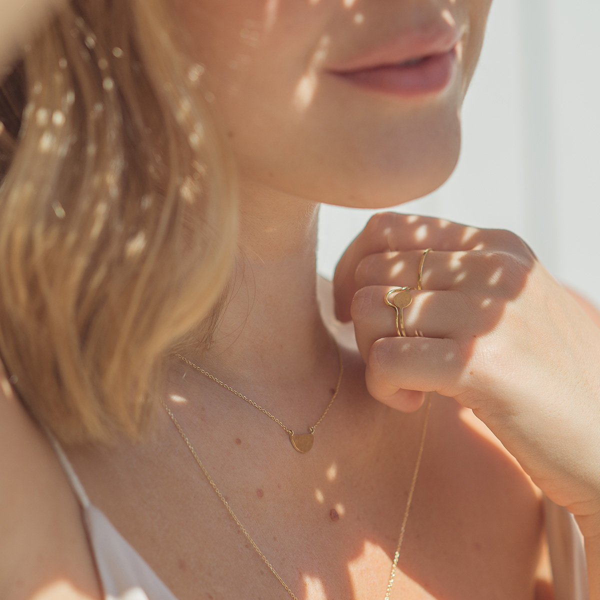 Mulher usando colares feitos a mão em ouro 18k com meia lua martelada