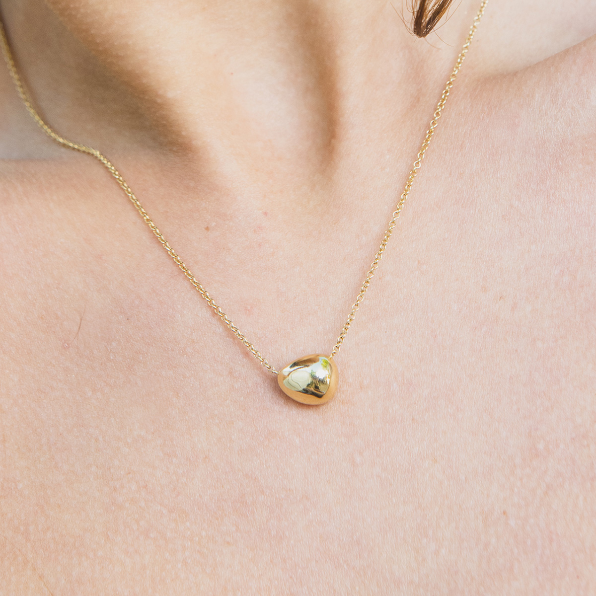 Mulher usando Colar minimalista com compartimento para cinzas feito a mão em ouro 18k