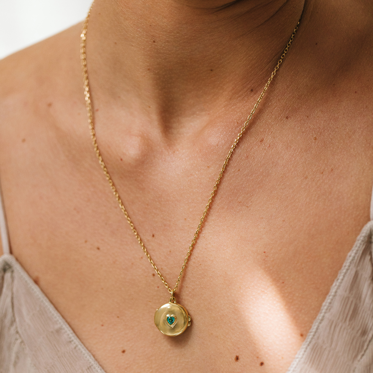 Mulher usando corrente cartier média minimalista feita a mão em ouro 18k com pingente de relicário
