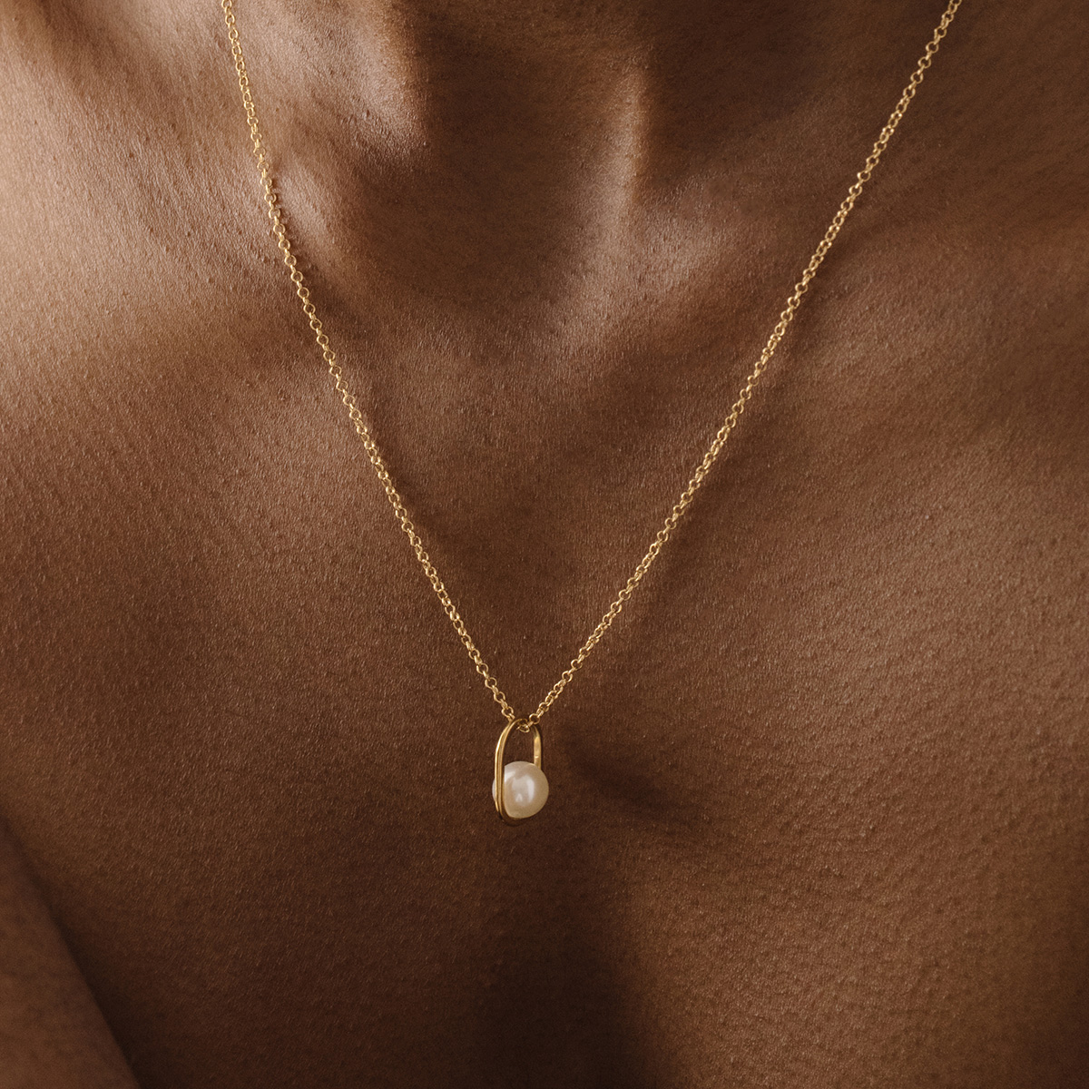 Mulher usando Corrente com Pingente feito a mão em ouro 18k em formato oval com pérola branca natural