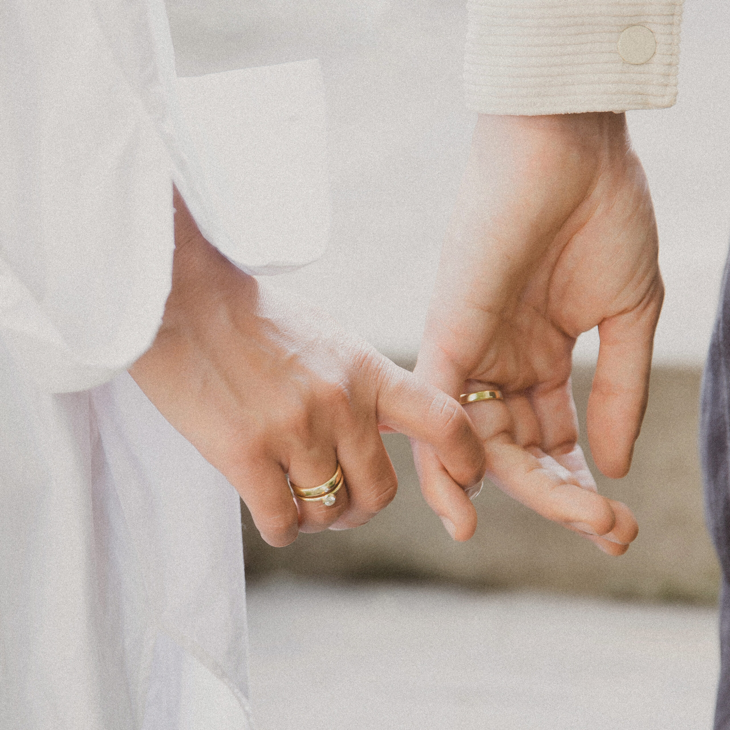 casal usando par de alianças minimalistas feitas à mão em ouro 18k com diamante