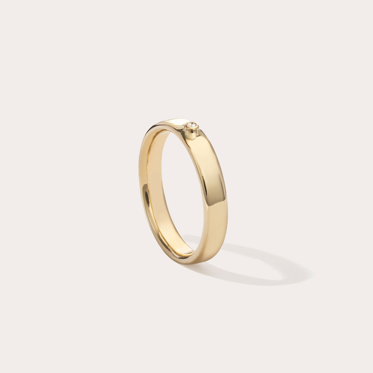 Aliança minimalista feita a mão em ouro 18k com diamante para casamentos sobre fundo branco