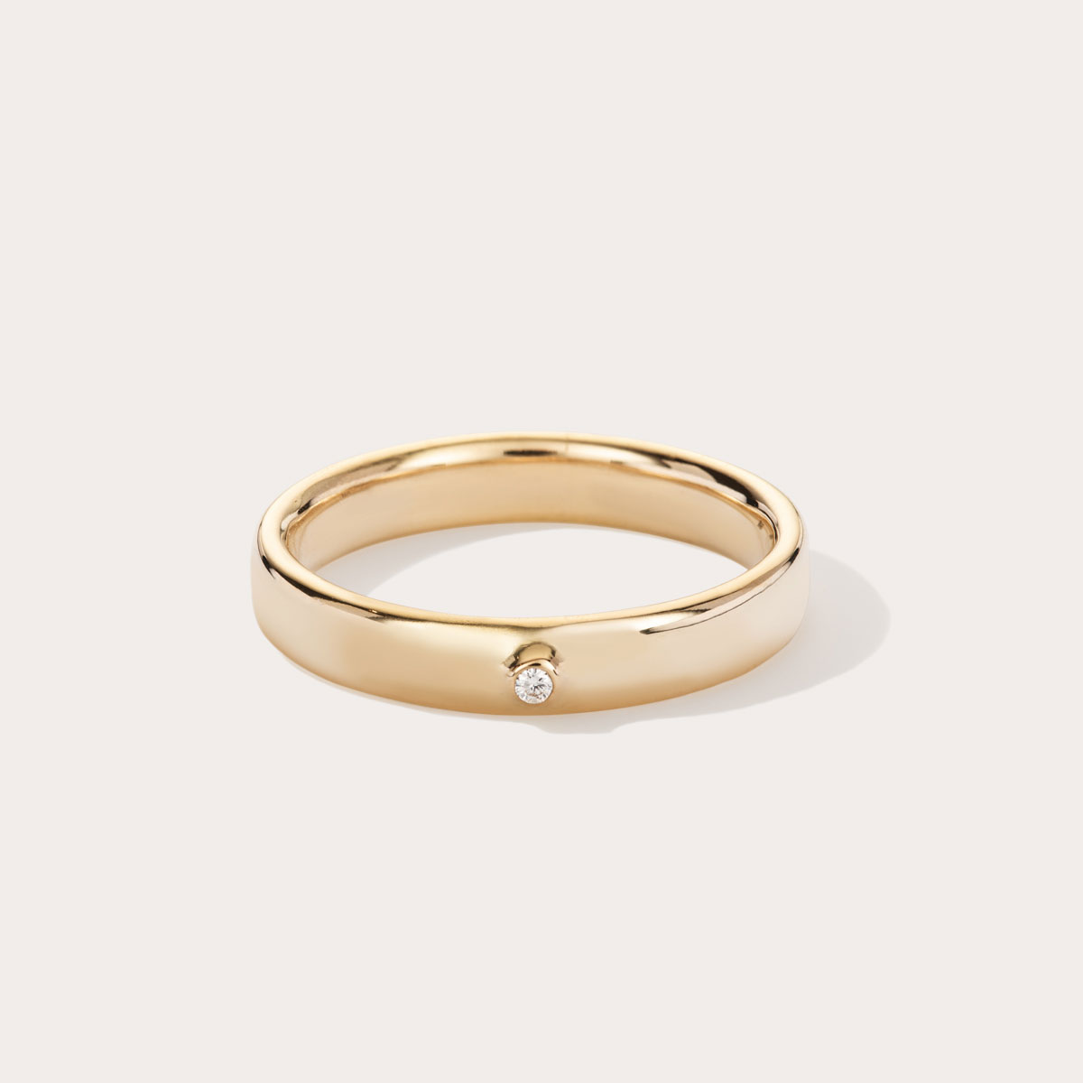 Aliança minimalista feita a mão em ouro 18k com diamante para casamentos sobre fundo branco