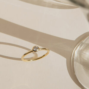 anel de noivado em ouro 18k e diamante minimalista e feito à mão sobre mesa