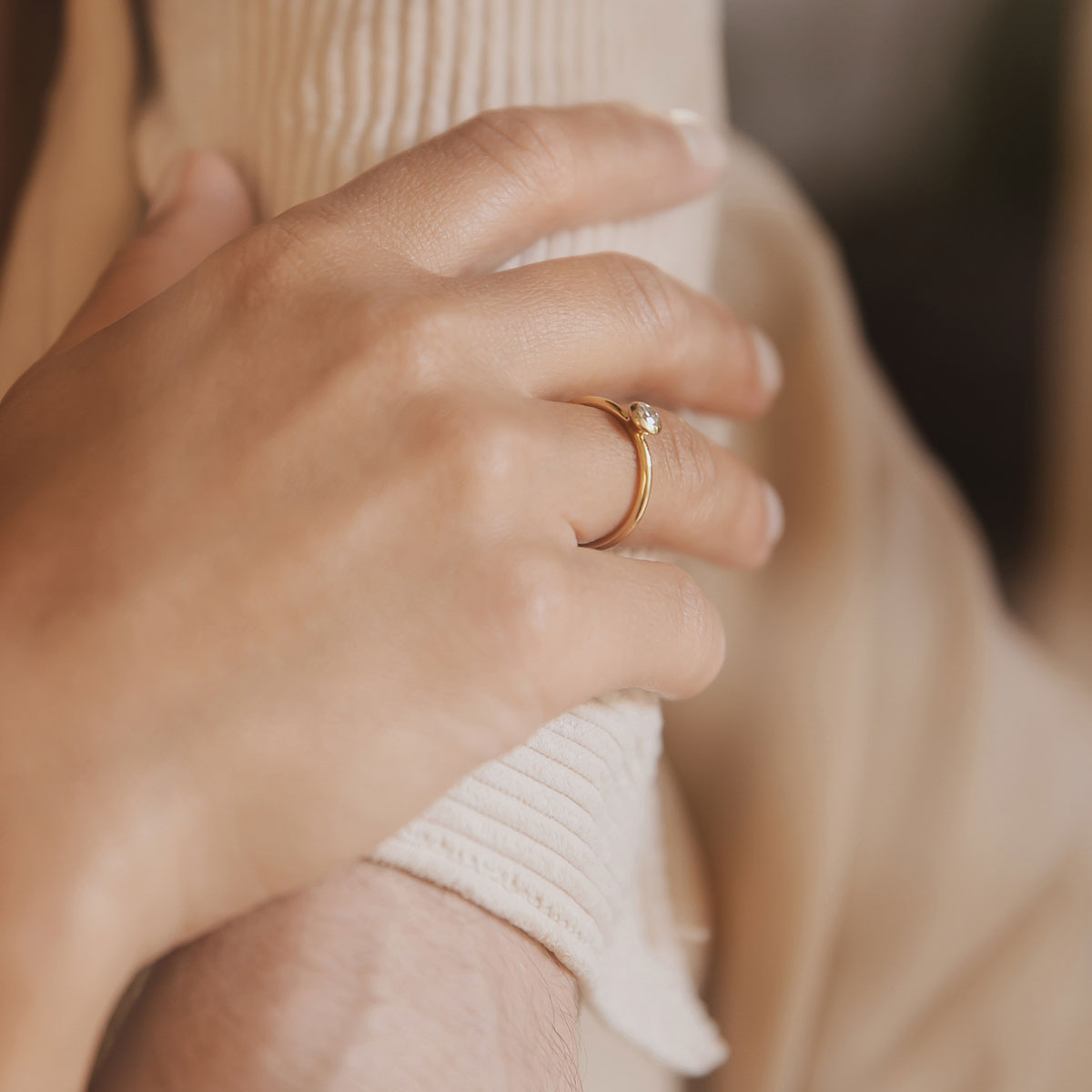 mão feminina usando anel de noivado minimalista de ouro 18k com diamante de 22p feito à mão