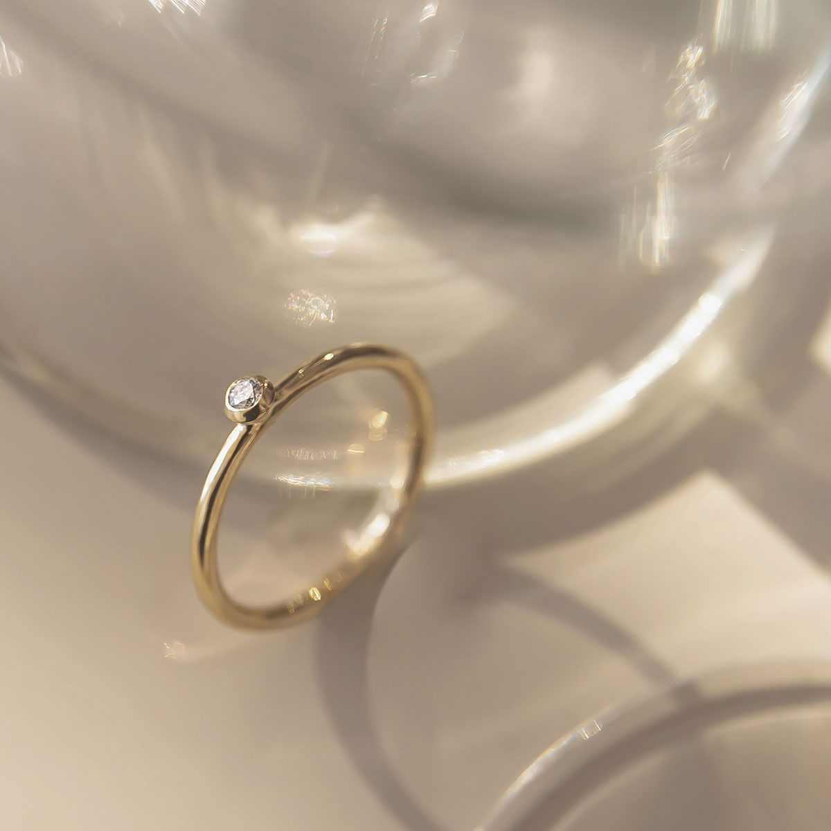 anel de noivado em ouro 18k e diamante minimalista e feito à mão sobre mesa