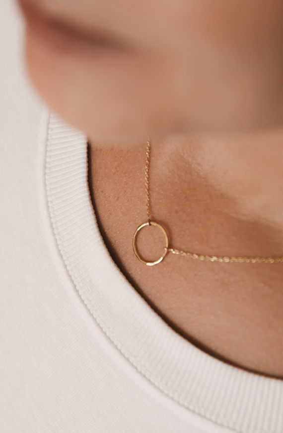 Mulher usando colar feito a mão em ouro 18k com círculo martelado minimalista