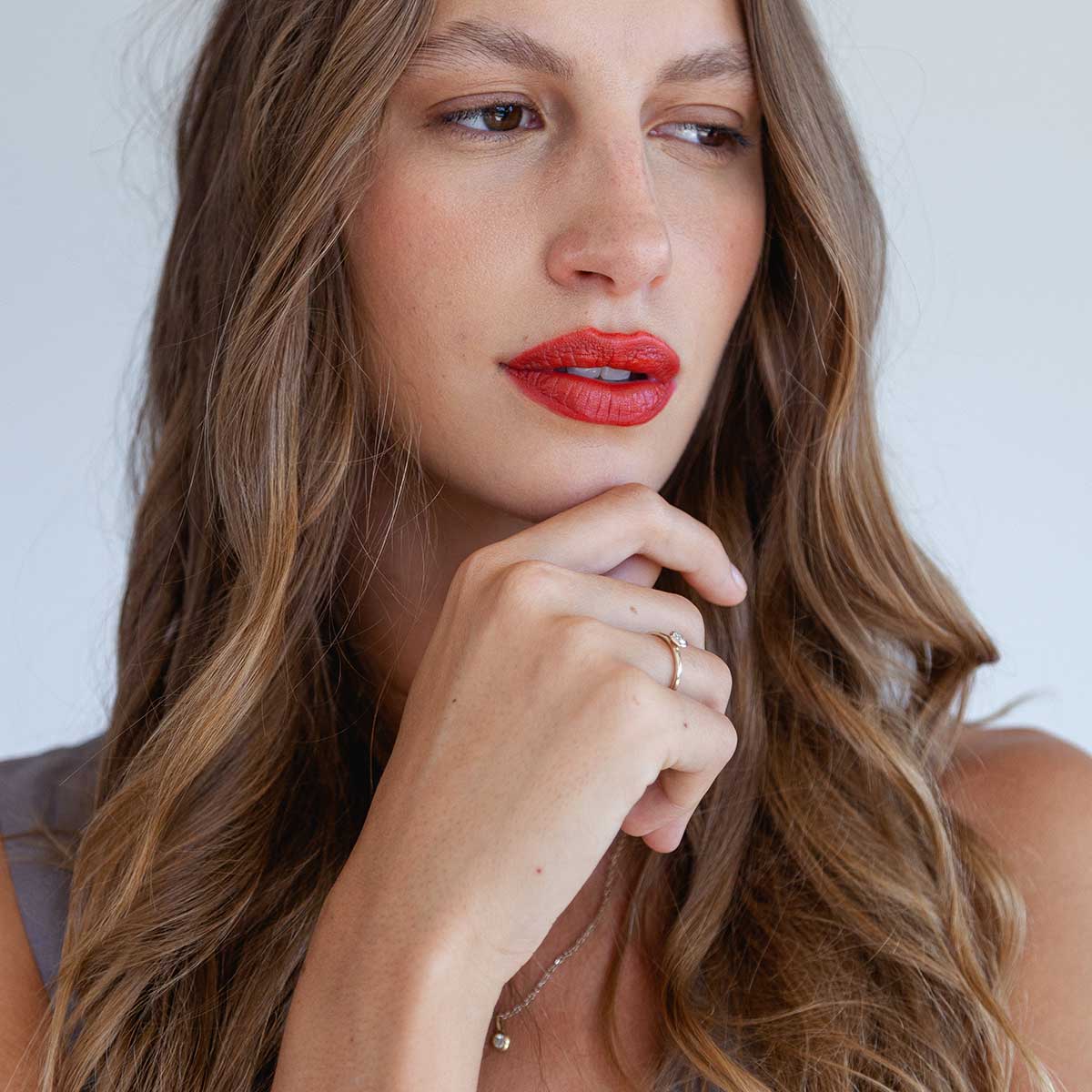 mulher usando anel de noivado minimalista de ouro 18k com diamante de 30p feito à mão