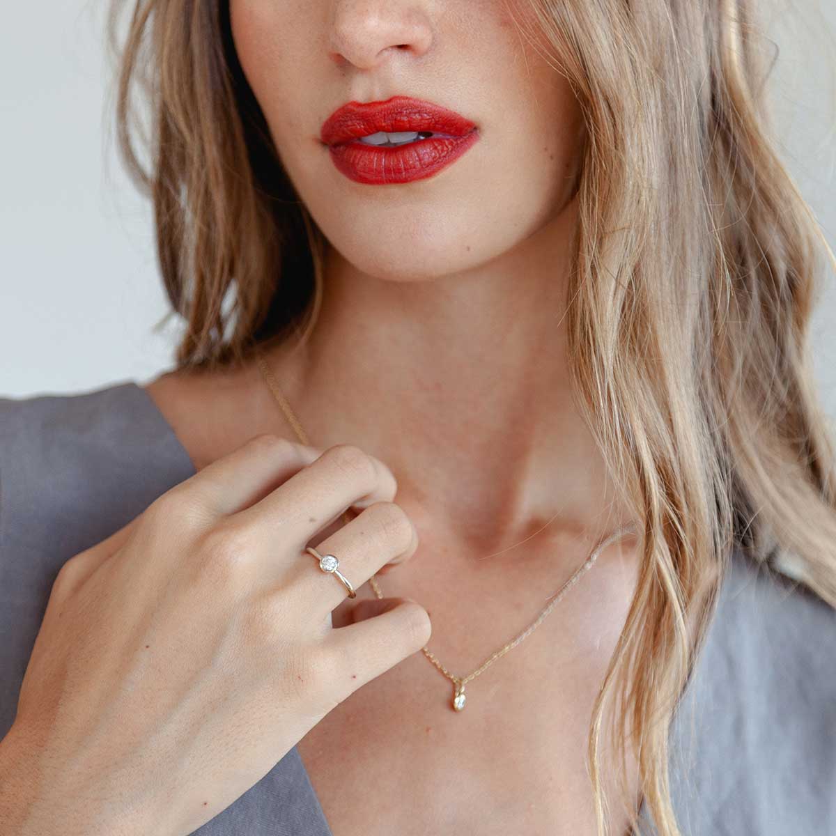 mulher usando anel de noivado minimalista de ouro 18k com diamante de 30p feito à mão