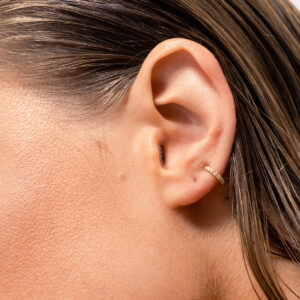Mulher usando unidade de Argolinha como piercing minimalista com diamantes feita a mão em ouro 18k