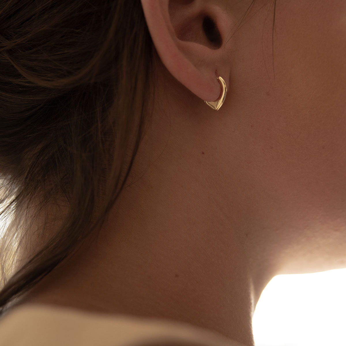 Mulher usando Brinco de argola em formato de gota minimalista feito a mão em ouro 18k