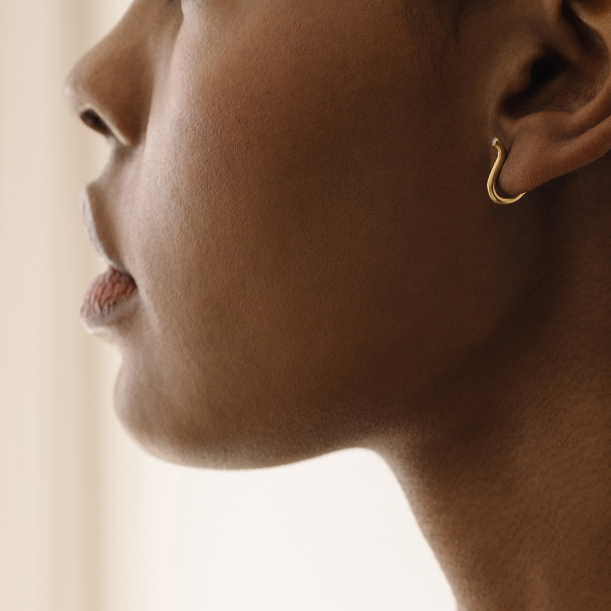 Mulher usando Brinco minimalista delicado feito a mão em ouro 18k em forma de V com diamante na ponta